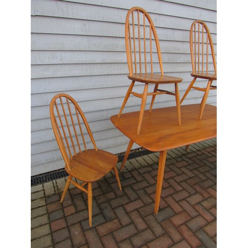 9344 - An Ercol light elm dining table and four high hoop back chairs. Table 152cm x 77cm x 71cm high