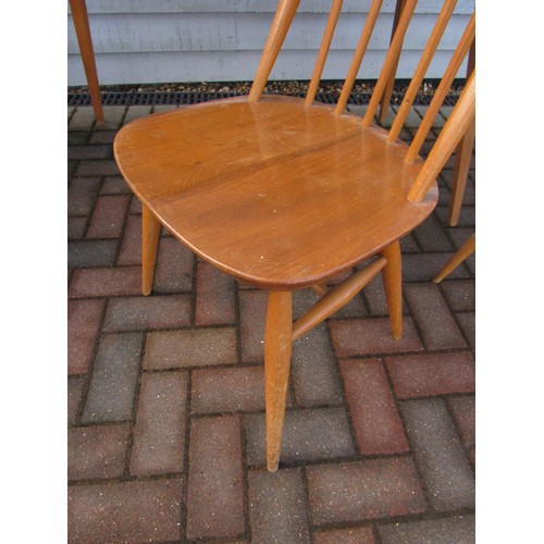 9344 - An Ercol light elm dining table and four high hoop back chairs. Table 152cm x 77cm x 71cm high