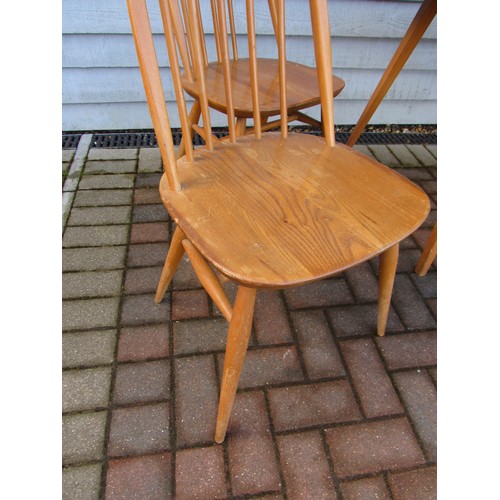 9344 - An Ercol light elm dining table and four high hoop back chairs. Table 152cm x 77cm x 71cm high