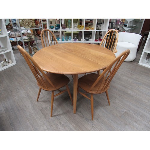 9358 - A light Ercol circular drop leaf kitchen/dining table with four high back Ercol chairs (3 + 1 carver... 