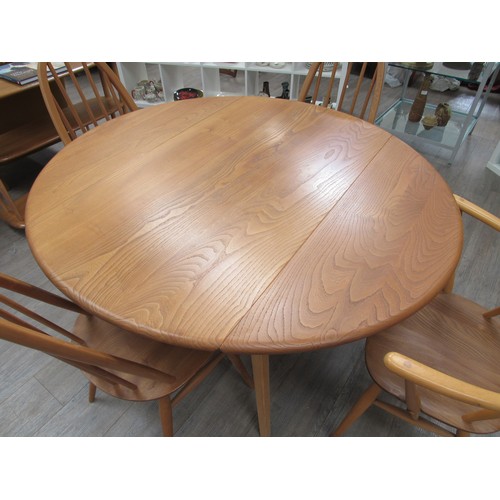 9358 - A light Ercol circular drop leaf kitchen/dining table with four high back Ercol chairs (3 + 1 carver... 