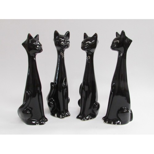 9024 - Four large 1950's vintage kitsch black pottery cats. Tallest  34cm