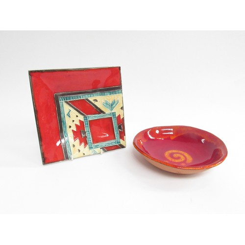 9042 - A square red studio pottery dish with painted marks to base and a red circular shallow bowl with ora... 