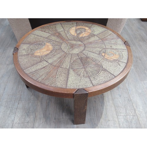 9365 - A Danish circular coffee table with stoneware tiled top and dark stained wooden frame. 108cm diamete... 