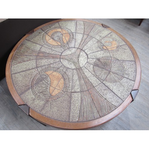 9365 - A Danish circular coffee table with stoneware tiled top and dark stained wooden frame. 108cm diamete... 