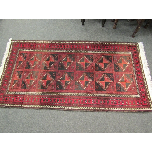 1560 - An Eastern red ground geometric design rug with tasselled ends, 153cm x 82cm   (R) £40