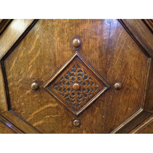 1011 - An early 20th Century oak sideboard, the two drawers over twin geometric moulded doors, on squashed ... 