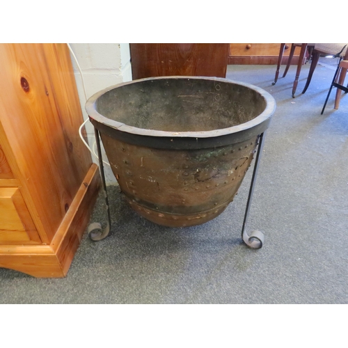 1015 - A rivetted copper copper on tripod footed stand, 44cm high x 51cm diameter