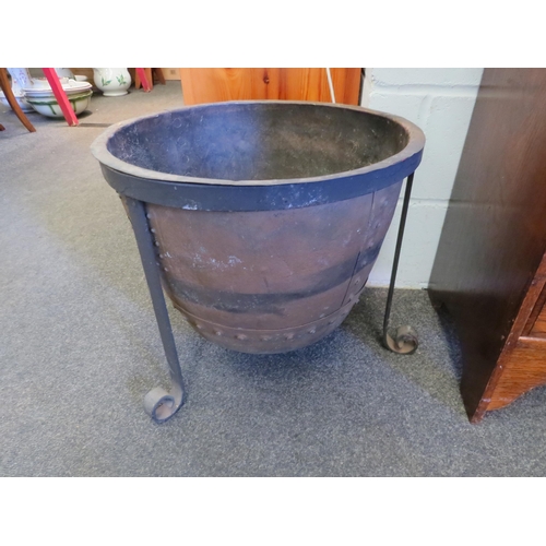 1015 - A rivetted copper copper on tripod footed stand, 44cm high x 51cm diameter