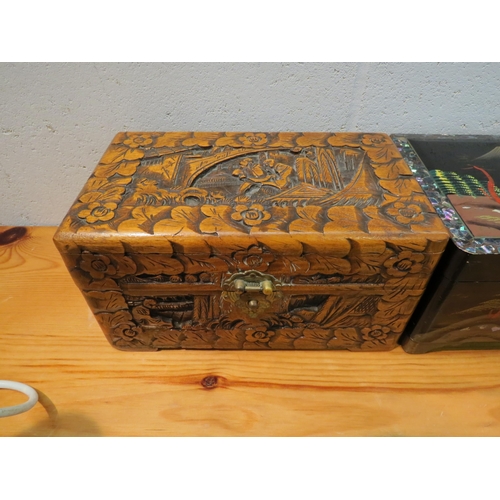 1026 - An Eastern carved jewellery box with floral and figural design together with a lacquered musical box... 