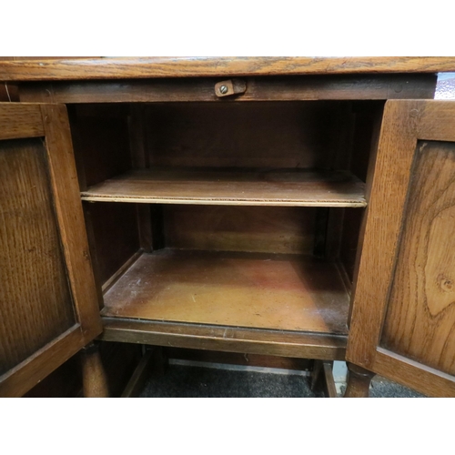 1044 - A 20th century oak cabinet, the twin doors with foliate carved design, turned legs joined by a box s... 