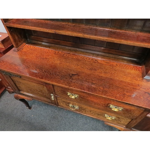 1050 - A Georgian style oak dresser, the plate rack top over two drawer, single door base, raised on cabrio... 