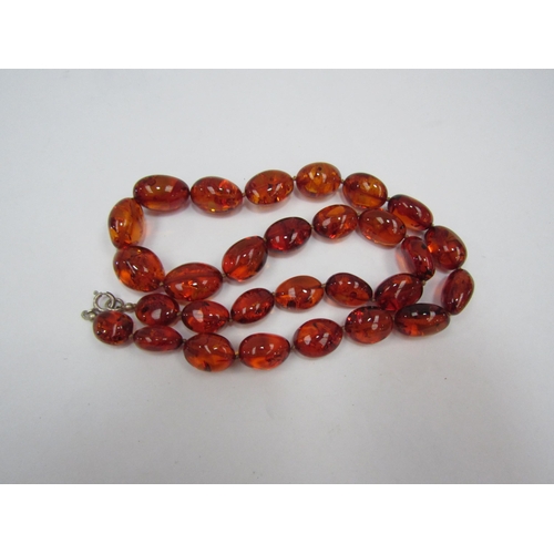 1338 - An amber bead necklace and two amber pendants in  the art nouveau style