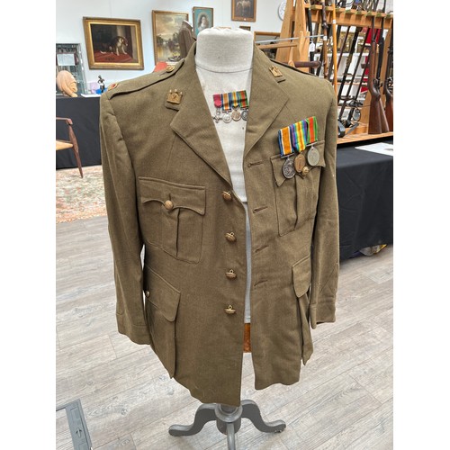 9001 - A WWI officer's jacket and peaked cap together with medals, holster, Sam Browne belt with frog and e... 