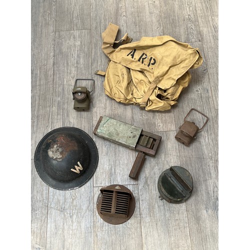 9037 - A British ARP warden's helmet with ARP satchel, gas rattle, lanterns, car head lamp covers etc