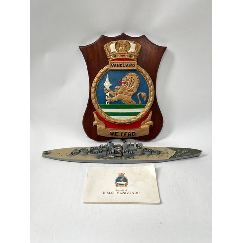 9073 - An HMS Vanguard crest together with a souvenir book and model (3)