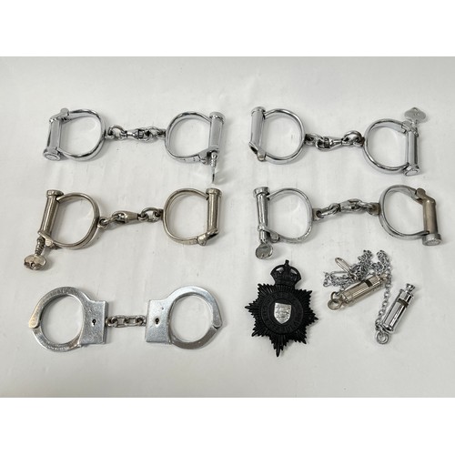 9077 - Five pairs of 20th Century handcuffs including Hiatt, together with two police whistles and King's C... 