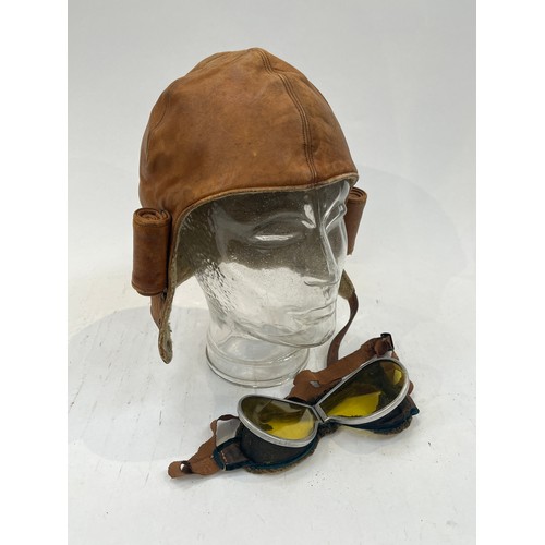 9119 - A mid 20th Century tan leather flying helmet together with a pair of pre-war flying goggles a/f (2)