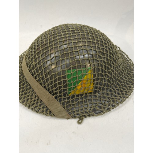 9122 - Two Belgian helmets, one with unit mark, and a camo net