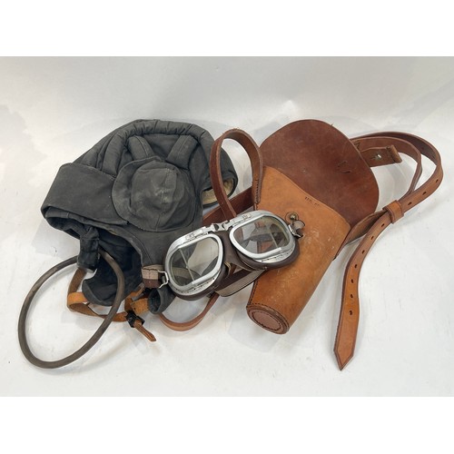 9133 - A brown leather pistol holster, a post-war set of goggles and a 1950’s tank crew helmet (3)