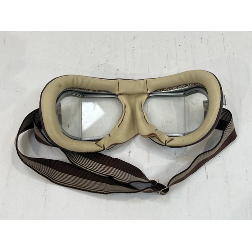 9133 - A brown leather pistol holster, a post-war set of goggles and a 1950’s tank crew helmet (3)