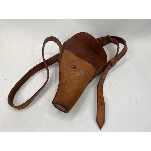 9133 - A brown leather pistol holster, a post-war set of goggles and a 1950’s tank crew helmet (3)