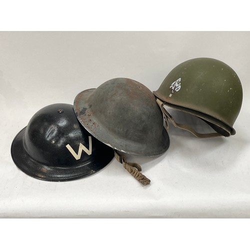 9135 - A British Army helmet repainted in black with W for Warden, a helmet shell and a post-war US helmet ... 