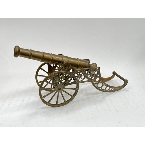 9146 - A decorative brass signal cannon with ornate wheeled carriage, 41cm long