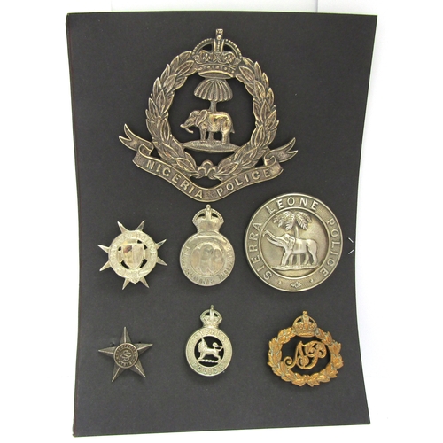 9423 - Seven various colonial police badges including Nigeria pouch badge, Sierra leone helmet badge, cap b... 