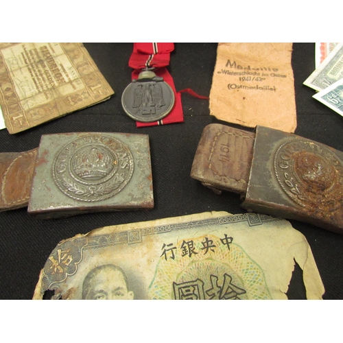 9452 - A cash tin containing a German Eastern Front Medal 1941/42 and two WWI German belt buckles (both cor... 