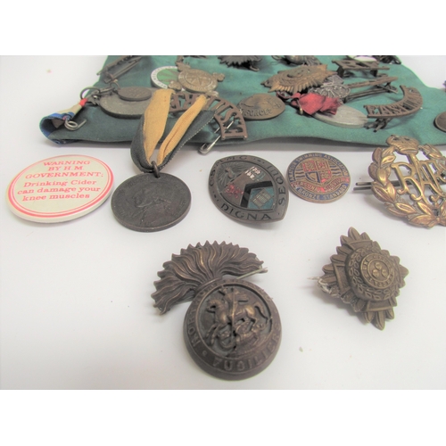 9492 - A quantity of military insignia including shoulder titles and cap badges including RAF and Red Cross