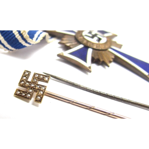 9477 - A gold stick pin tin of swastika form set with seed pearls, together with an interwar era Reichsbann... 