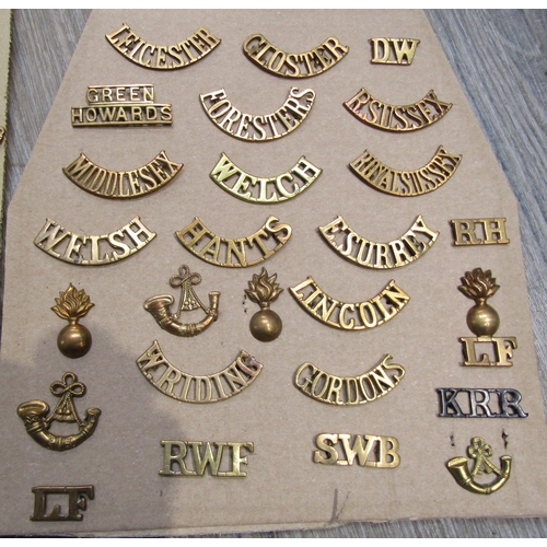 9438 - A collection of British Regimental insignia, mainly brass shoulder titles including Somerset and Cor... 