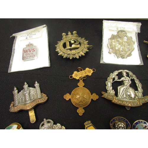 9449 - A quantity of British insignia including WWI era Norfolk and Suffolk Regiment cap badges, silver ARP... 