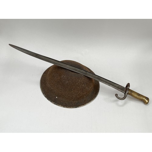 9277 - A 19th Century French Chassepot bayonet, no scabbard, together with a British WWII helmet shell, cor... 