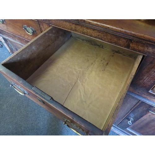 1009 - An early 19th Century stained oak dresser with three drawers and cupboards to the base and a board-b... 