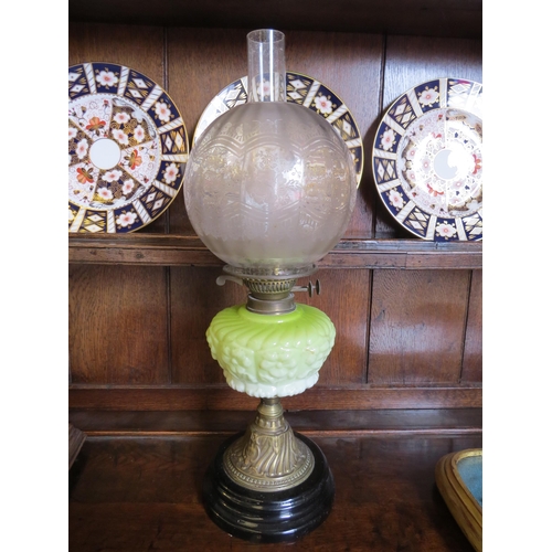 1016 - A Victorian oil lamp, the frosted clear glass spherical shade over a pale green reservoir to a brass... 