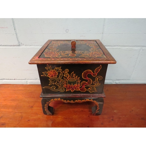 1046 - A Chinese lacquered lidded storage box with floral design on raised feet, 28cm high