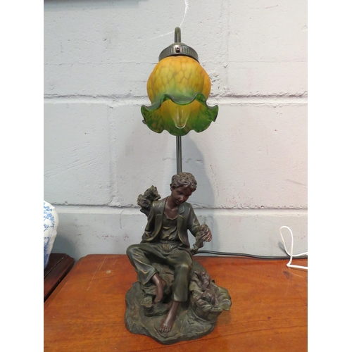 1054 - A figural table lamp in the form of a boy with basket of dogs, green and yellow shade