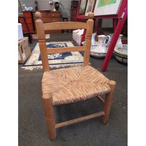 1143 - A rush seated pine child's chair on stretcher base