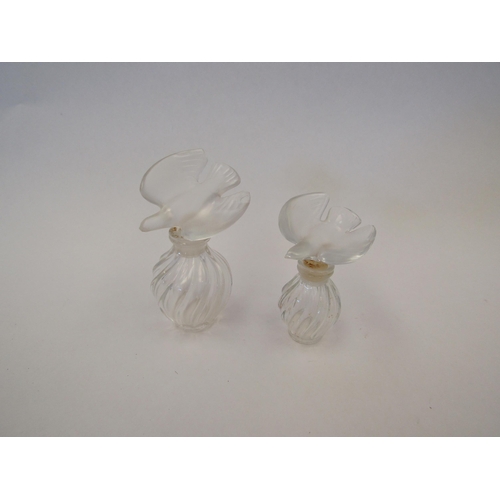 1338 - A graduated pair of Lalique perfume bottles, chips to wings of stopper