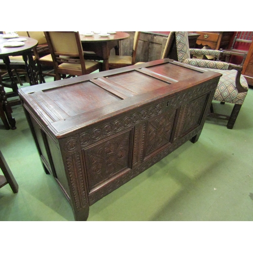 4017 - A 17th Century and later pegged oak three panelled coffer the hinged lid over a carved front on stil... 