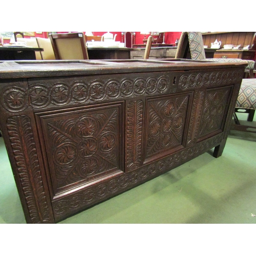 4017 - A 17th Century and later pegged oak three panelled coffer the hinged lid over a carved front on stil... 