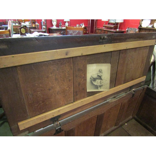 4017 - A 17th Century and later pegged oak three panelled coffer the hinged lid over a carved front on stil... 