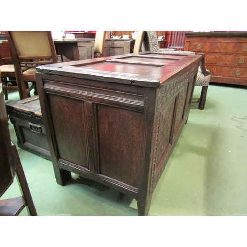 4017 - A 17th Century and later pegged oak three panelled coffer the hinged lid over a carved front on stil... 