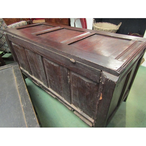 4017 - A 17th Century and later pegged oak three panelled coffer the hinged lid over a carved front on stil... 