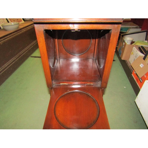 4217 - An Arts & Crafts mahogany jardinière stand the four drop down doors having circular dished shelves o... 