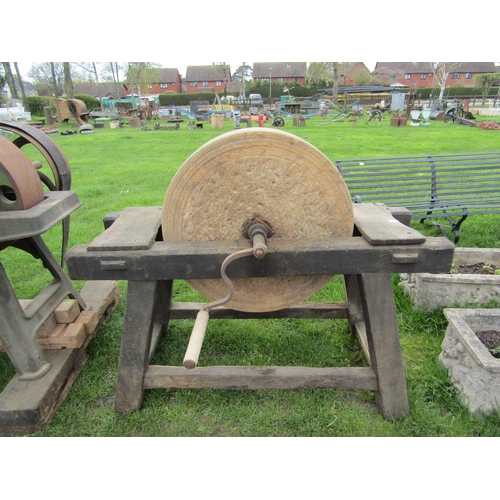 5452 - A large grinding stone with handle on wooden frame