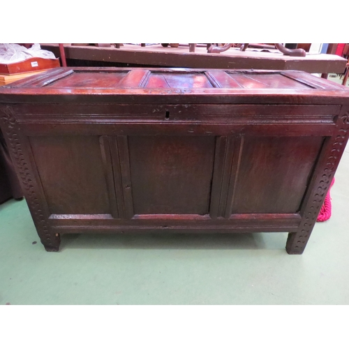 4004 - An 18th Century pegged oak three panel coffer, the ring pin hinged lid over stile feet with whorl sp... 