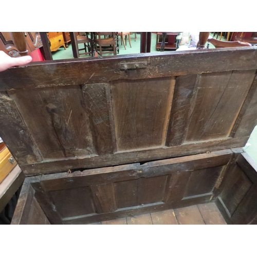 4004 - An 18th Century pegged oak three panel coffer, the ring pin hinged lid over stile feet with whorl sp... 